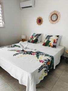 2 camas en una habitación con paredes blancas en Villa Pacifico avec spa, en Baillif