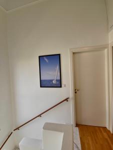 una habitación con una silla blanca y una foto en la pared en Theros Aegean Villa en Iraklitsa