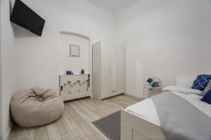 a white bedroom with a bed and a bean bag chair at Garden Apartment Ultracentral in Oradea