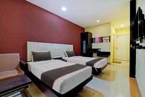 2 camas en una habitación con paredes rojas en Collection O 81666 Cedar Hotel en Kāndūr