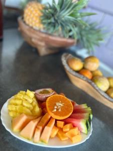 a plate of fruit on a table with baskets of pineapple at chambres d'hôtes le puits des français in Saint-Philippe