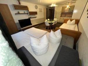 1 dormitorio con 2 camas blancas y sala de estar en Apartment Stabel 8,1 km von Europa Park, en Kippenheim