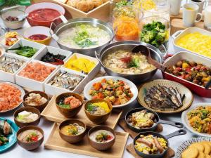 a table with many bowls of different types of food at Vessel Hotel Fukuoka Kaizuka in Fukuoka