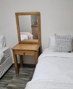 a mirror sitting on a table next to a bed at HAGAR LODGE in Mid Illovo +40 photos