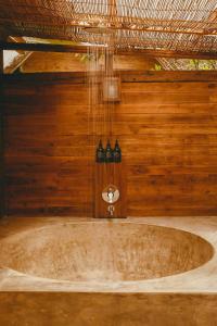 uma banheira num quarto com uma parede de madeira em Green Escape Eco Resort em Uluwatu