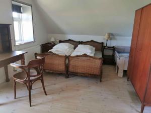a bedroom with a bed and a chair and a table at Lovely Farmhouse For The Whole Family in Slagelse