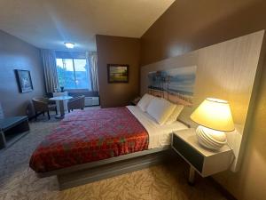 una camera d'albergo con un letto con una lampada e un tavolo di Hotel Pacific Garden a Gardena