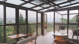 a screened in porch with a table and chairs at Zhenai B&B in Daxi