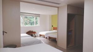 a bedroom with two beds and a window at Zhenai B&B in Daxi
