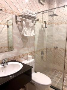 La salle de bains est pourvue d'une douche, de toilettes et d'un lavabo. dans l'établissement Madella Hotel, à Cần Thơ