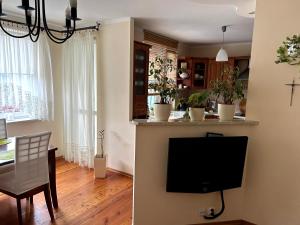 a living room with a television and a dining room at Apartament Kozia in Wrocław