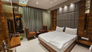 a bedroom with a large white bed in a room at HOTEL PUSHPA INN in Ambaji