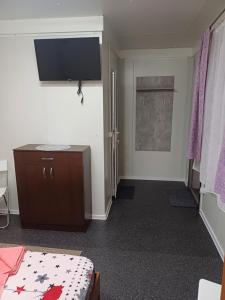 a room with a bed and a tv on the wall at Monica și Tibo in Sfântu Gheorghe