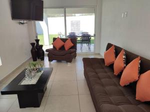 Una sala de estar con un sofá marrón y una mesa. en CASA MYAA, casa para noche, día, fin de semana, semana y mes, en Cuernavaca