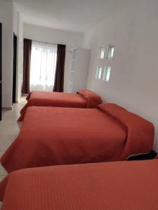 Cuatro camas en una habitación con sábanas rojas. en CASA MYAA, casa para noche, día, fin de semana, semana y mes, en Cuernavaca 3 fotos más