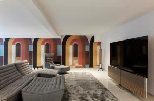 a living room with a couch and a television at H2O Art Beach Villa Crete in Agios Nikolaos