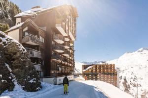 una persona esquiando en la nieve frente a un edificio en Résidence Antarès - maeva Home - Appartement 2 Pièces 5 Personnes - Sélec 13, en Avoriaz