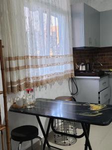 cocina con mesa con 2 sillas y ventana en 53 jincharadze street, en Batumi