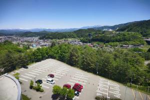 uma vista aérea de um parque de estacionamento com uma cidade em Hotel Associa Takayama Resort em Takayama