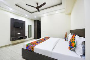 Schlafzimmer mit einem Bett und einem Flachbild-TV in der Unterkunft FabHotel Dwarka Residency in Neu-Delhi