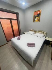 Un dormitorio con una gran cama blanca en una habitación. en One Global Family Guest House Samarkand II, en Samarkand