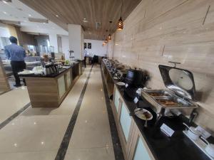 uma cozinha com um balcão longo num restaurante em Grand Continent Hosur A Sarovar Portico Affiliate Hotel em Hosur