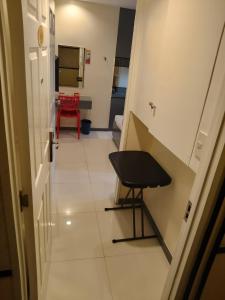 a hallway with a table and a chair in a room at Hotel Sogo Avenida in Manila
