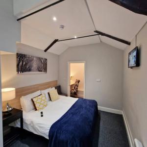 a bedroom with a bed and a tv on the wall at Stay Norwich Apartments 17colgate in Norwich