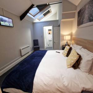 a bedroom with a large white bed with a skylight at Stay Norwich Apartments 17colgate in Norwich