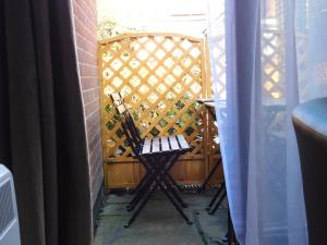 a wooden chair sitting in front of a gate at City Center Ground Floor Flat With Patio &parking in Norwich