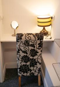 a chair sitting in front of a desk with a lamp at City Center Ground Floor Flat With Patio &parking in Norwich +32 photos