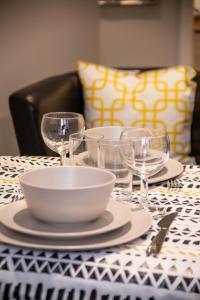 una mesa con platos y copas de vino. en Stay Norwich Apartments 17colgate en Norwich