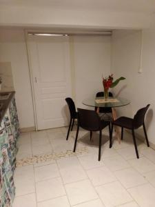 a dining room with a table and chairs and a door at Gites coeur des Antilles G in Trois-Rivières