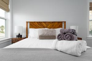 une chambre avec un lit blanc avec des serviettes dessus dans l'établissement Be A Nomad - Balcony peekaboo - Home for reunions, à Jacksonville Beach