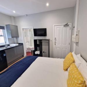 - une chambre avec un grand lit blanc et des oreillers jaunes dans l'établissement Stay Norwich Apartments Riverside House Apart-3, à Norwich