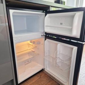an open refrigerator with its door open and its at Stay Norwich Apartments Riverside House Apart-3 in Norwich