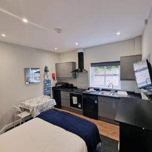 a room with a kitchen with a bed and a sink at Stay Norwich Apartments Riverside House Apart-3 in Norwich