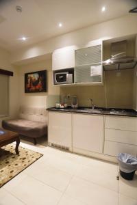 una cocina con fregadero y un sofá en una habitación en Naylover Hotel Suites en Amán