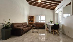 salon ze skórzanymi meblami i stołem w obiekcie KATKA Hostel Paphos w Pafos