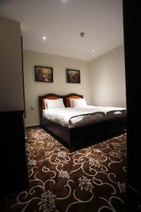 1 dormitorio con 1 cama grande en una habitación en Naylover Hotel Suites en Amán