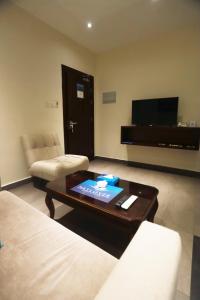 uma sala de estar com um sofá e uma mesa de centro em Naylover Hotel Suites em Amã