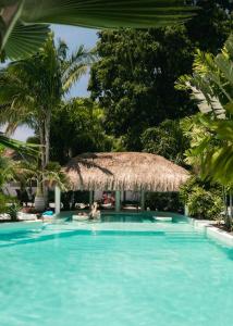 a person swimming in a swimming pool with a thatch umbrella at Secret paradise moalboal in Moalboal