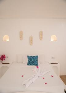 a white bedroom with a white bed with blue accents at Secret paradise moalboal in Moalboal