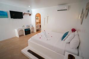 a living room with a white couch and a television at Secret paradise moalboal in Moalboal