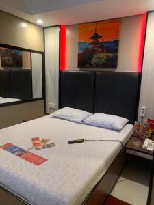 a bedroom with a bed with a phone on it at Hotel Sogo Malate in Manila