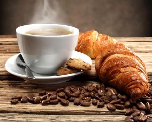 una tazza di caffè, un cornetto e caffè in grani di Imperatore a Roma