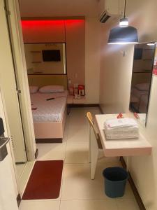 a small room with a bed and a table in it at Hotel Sogo Malate in Manila