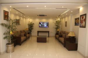 a waiting room with couches and a flat screen tv at Fort Continental Hotel in Peshawar