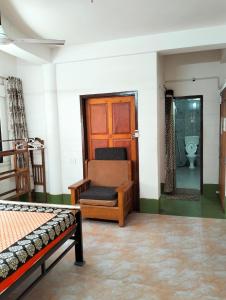 Habitación con cama, silla y aseo. en Yangzom Homez en Siliguri