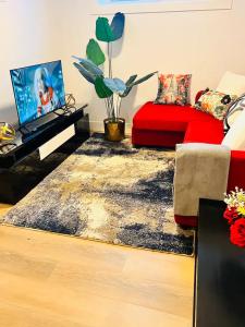 a living room with a red couch and a red rug at B21 River Valley 2bd Basement Suite in Edmonton